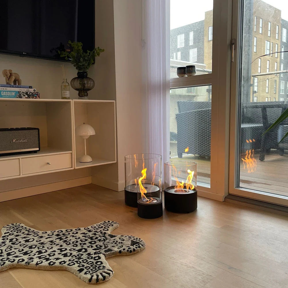 Two Kennington fireplaces lit on a living room floor beside a leopard-print rug, genuine customer photo